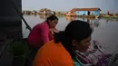 Perempuan berbelanja kosmetik di sebuah desa terapung di sepanjang sungai Siem Reap, Kamboja (5/12/2019). Sungai Siem Reap adalah sungai yang mengalir melalui Provinsi Siem Reap, di barat laut Kamboja. (AFP/Manan Vatsyayana)