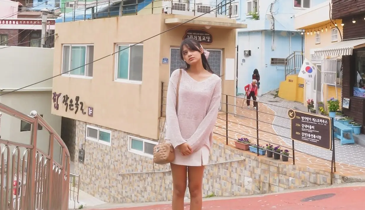 Callista Arum juga mengunjungi Gamcheon Culture Village. Gamcheon Culture Village merupakan daerah di Korea Selatan yang memiliki rumah lucu warna warni. Gamcheon Culture Village ini terletak di Busan. Ketika kunjungi Gamcheon Culture Village, Callista Arum kenakan busana simpel dan lucu yakni baju oversize yang dipadukan dengan rok mini warna putih. (Liputan6.com/IG/@callistarum)