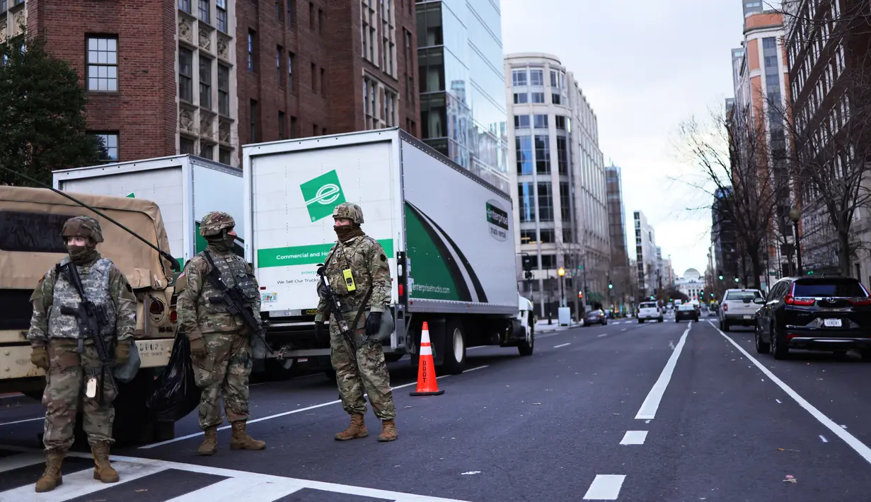 Tentara Garda Nasional berjaga di sebuah blok jalan di Washington, DC, Senin (18/1/2021). Menurut laporan, 25.000 tentara Garda Nasional akan menjaga kota tersebut sebagai persiapan untuk pelantikan Joe Biden sebagai Presiden ke-46 Amerika Serikat. (Michael M. Santiago/Getty Images/AFP)