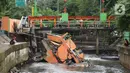 Warga melihat pos pantau Pintu Air yang rubuh di wilayah Palmerah, Jakarta, Selasa (6/2/2024). (Liputan6.com/Herman Zakharia)