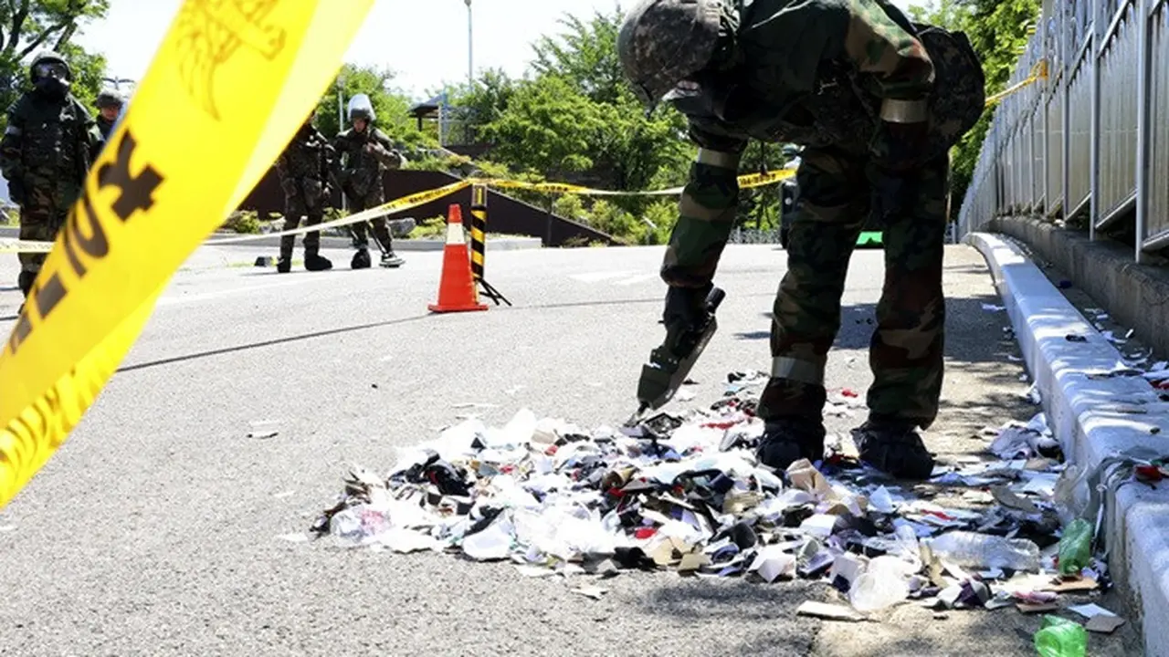 Tentara Korea Selatan yang mengenakan alat pelindung diri memeriksa sampah dari balon yang dikirim oleh Korea Utara di Incheon, Korea Selatan, Minggu (2/6/2024).