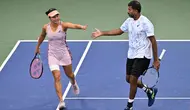 Petenis terbaik Indonesia, Aldila Sutjiadi yang berpasangan dengan petenis India, Rohan Bopanna sukses menembus babak semifinal nomor ganda campuran turnamen tenis Grand Slam US Open 2024 usai menaklukkan unggulan keempat yang berstatus juara Grand Slam yang juga peraih medali emas Olimpiade, Barbora Krejcikova/Matthew Ebden pada babak perempat final di court 5 USTA Billie Jean King National Tennis Center, New York City, Amerika Serikat, Selasa (3/9/2024) dini hari WIB. Dalam laga yang berlangsung dalam 93 menit, Aldila/Rohan menang atas pasangan gado-gado Republik Ceska/Australia tersebut dengan skor 7-6 (4), 2-6 dan 10-7. (Chryslène Caillaud/Athletica Company)