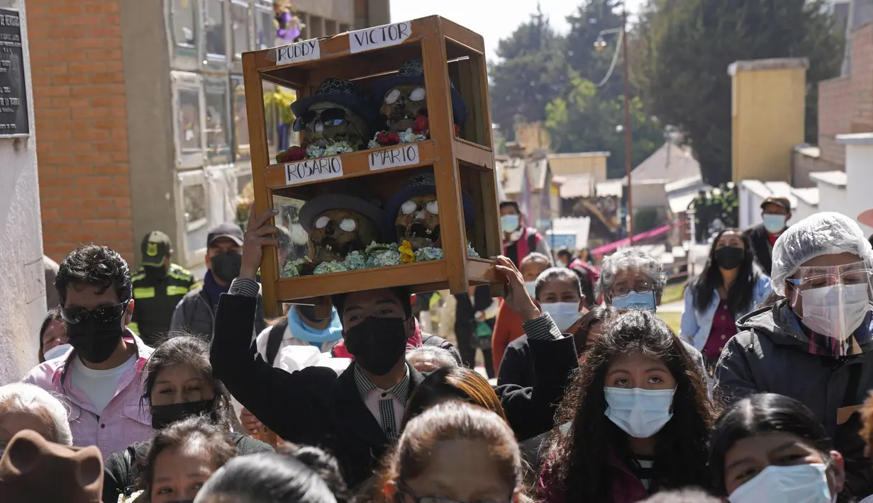 Seseorang membawa sekotak tengkorak manusia yang dihias di Pemakaman Umum untuk diberkati oleh seorang imam pada Festival Natitas di La Paz, Bolivia, Selasa (8/11/2022). Tradisi tahunan ini merayakan kematian di Bolivia dengan tengkorak yang dirawat dan didekorasi oleh mereka yang menggunakannya sebagai jimat untuk perlindungan. (AP Photo/Juan Karita)