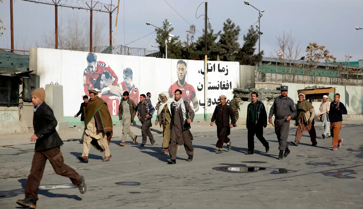 Kerabat pasien berlarian keluar menyusul serangan militan di rumah sakit militer Kabul, Afganistan, Rabu (8/3). Sejumlah pria berkostum dokter menyerang RS tersebut dan terlibat baku tembak beberapa jam dengan pasukan keamanan (AP Photos/Massoud Hossaini)