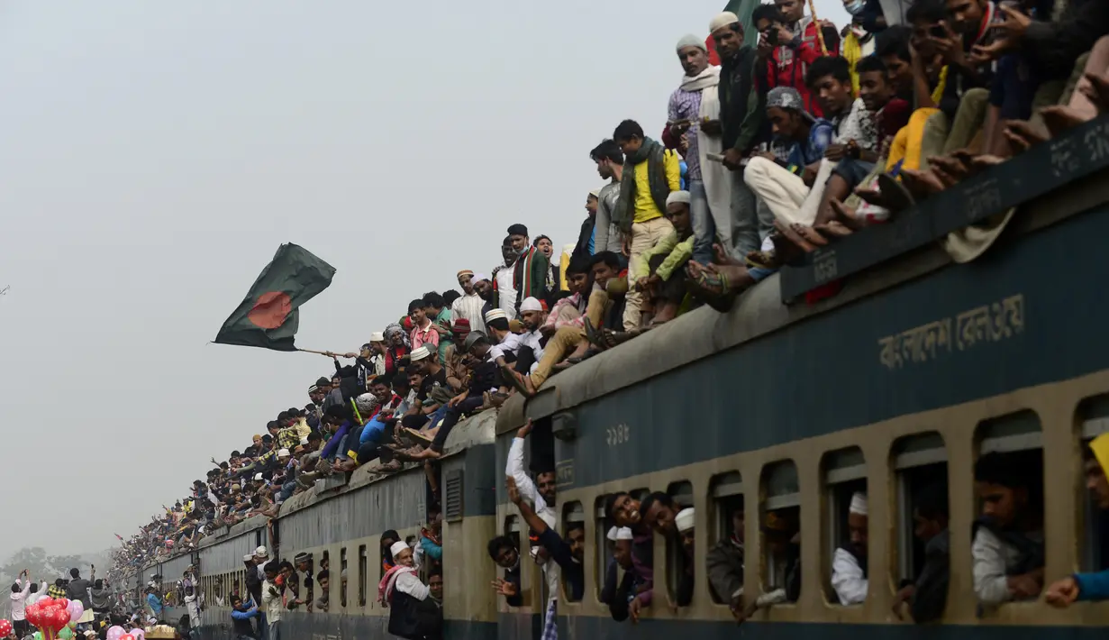 Tak hanya menaiki atap gerbong, umat Muslim Bangladesh juga terlihat berdesakan di jendela dan pintu kereta api usai mengikuti Akheri Munajat, atau doa terakhir, di Biswa Ijtema,  10 Januari 2016. (AFP PHOTO/Munir uz ZAMAN)