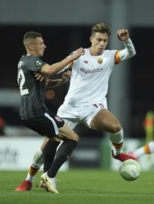 Bek AS Roma Riccardo Calafiori berebut bola dengan penyerang Zorya Luhansk, Vladyslav Kabaiev pada lanjutan matchday kedua Grup C Liga Konferensi Eropa, Jumat (1/10/2021) dini hari WIB. AS Roma menang meyakinkan 3-0. (AP Photo/Oleg Kozin)