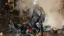 Untuk mencegah meluasnya kerusuhan tersebut, polisi melakukan tindakan keras terhadap para perusuh dengan menangkap serta menembakkan gas air mata agar massa bubar. (AP/Geert Vanden Wijngaert)