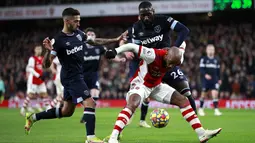 Penyerang Arsenal Alexandre Lacazette berebut bola dengan pemain West Ham United Manuel Lanzini dan pArthur Masuaku dalam laga pekan 17 Liga Inggris di Emirates Stadium, Kamis dini hari WIB (16/12/2021). Arsenal sukses kalahkan tamunya West Ham dengan skor 2-0. (AP Photo/Ian Walton)