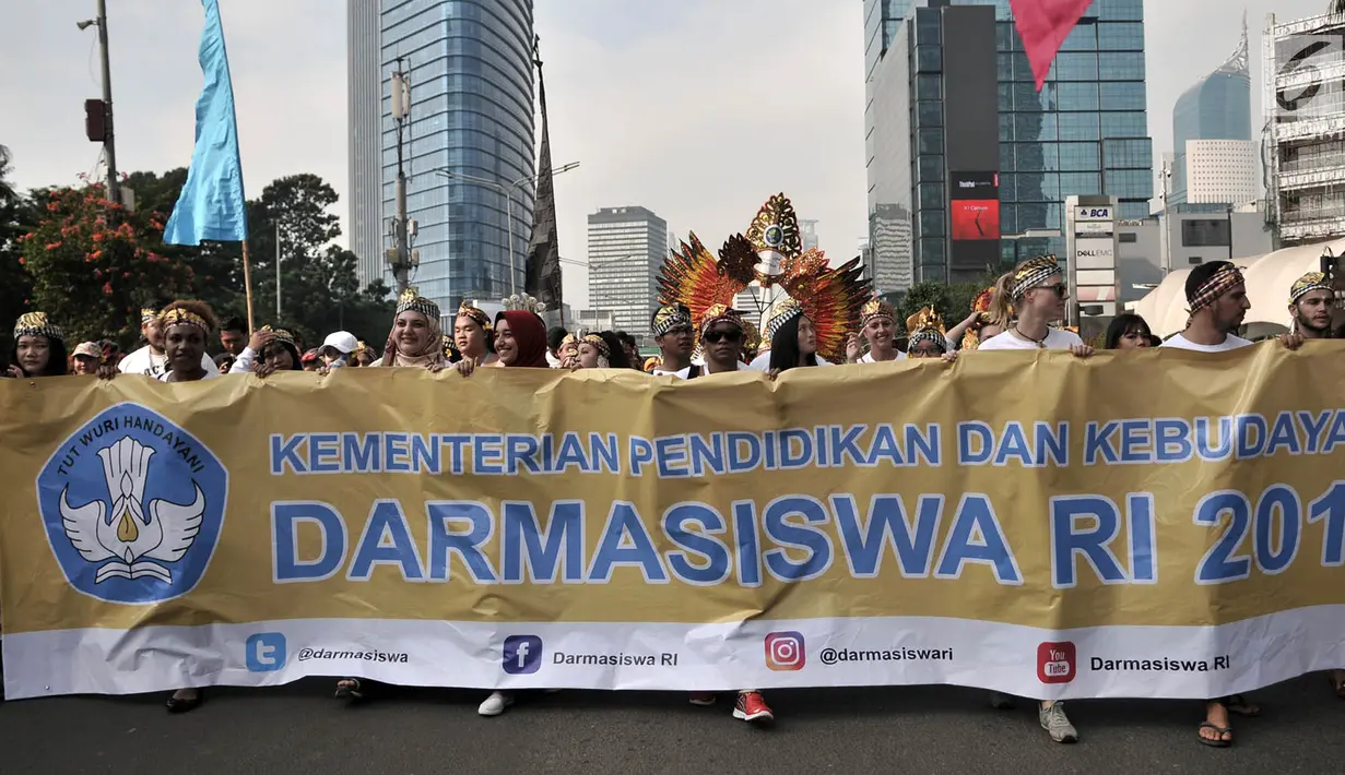Ratusan mahasiswa internasional mengenakan pakaian adat Indonesia sambil membawa spanduk saat pawai kelulusan beasiswa Kemendikbud di car free day (CFD), Jakarta, Minggu (6/5). (Merdeka.com/Iqbal Nugroho)