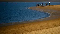 Peserta memacu kudanya saling balap di tepi pantai saat mengikuti lomba pacuan kuda pantai tahunan di Sanlucar de Barrameda, dekat Cadiz, Spanyol (17/8). Pacuan pertama digelar tahun 1845. (AFP Photo/Cristina Quicler)