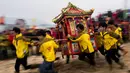 Penduduk desa membawa kuil Dewa Laut saat melakukan ritual di pantai desa Fuye, Provinsi Fujian, Tiongkok (5/3). Mereka adalah komunitas nelayan setempat yang menggelar ritual kepercayaan. (AFP Photo/Johannes Eisele)