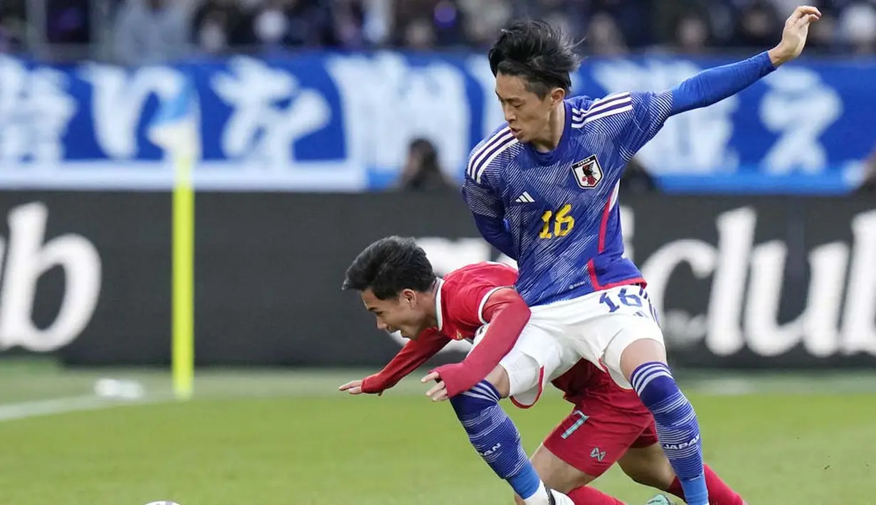 Pemain Jepang, Seiya Maikuma, berebut bola dengan pemain Thailand, Supachok Sarachat, pada laga uji coba di Stadion Nasional Jepang, Tokyo, Senin (1/1/2023). (AP Photo/Shuji Kajiyama)
