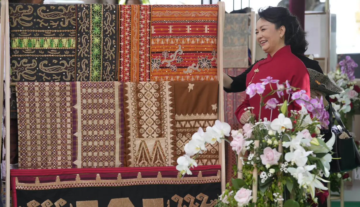 <p>Ibu Negara China Peng Liyuan melihat pameran kain tradisional Indonesia dalam rangkaian kegiatan Konferensi Tingkat Tinggi (KTT) G20 di Sofitel Bali Nusa Dua Beach Resort, Nusa Dua, Bali, Indonesia, Selasa (15/11/2022). Pertemuan kemudian ditutup dengan jamuan makan siang bersama Ibu Iriana dengan para pendamping pemimpin negara-negara G20 serta lembaga internasional. (AP Photo/Firdia Lisnawati via Pool)</p>
