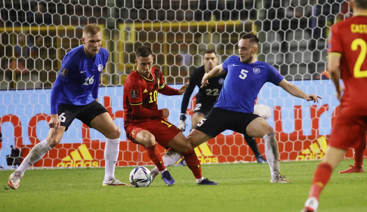 Gelandang Belgia, Eden Hazard (tengah) mengontrol bola dari kawalan pemain Estonia, Joonas Tamm dan Vladislav Kreida pada pertandingan pertandingan grup E kualifikasi Piala Dunia 2022 di stadion King Baudouin di Brussels, Minggu (14/11/2021). Belgia menang atas Estonia 3-1. (AP Photo/Olivier Mattys)