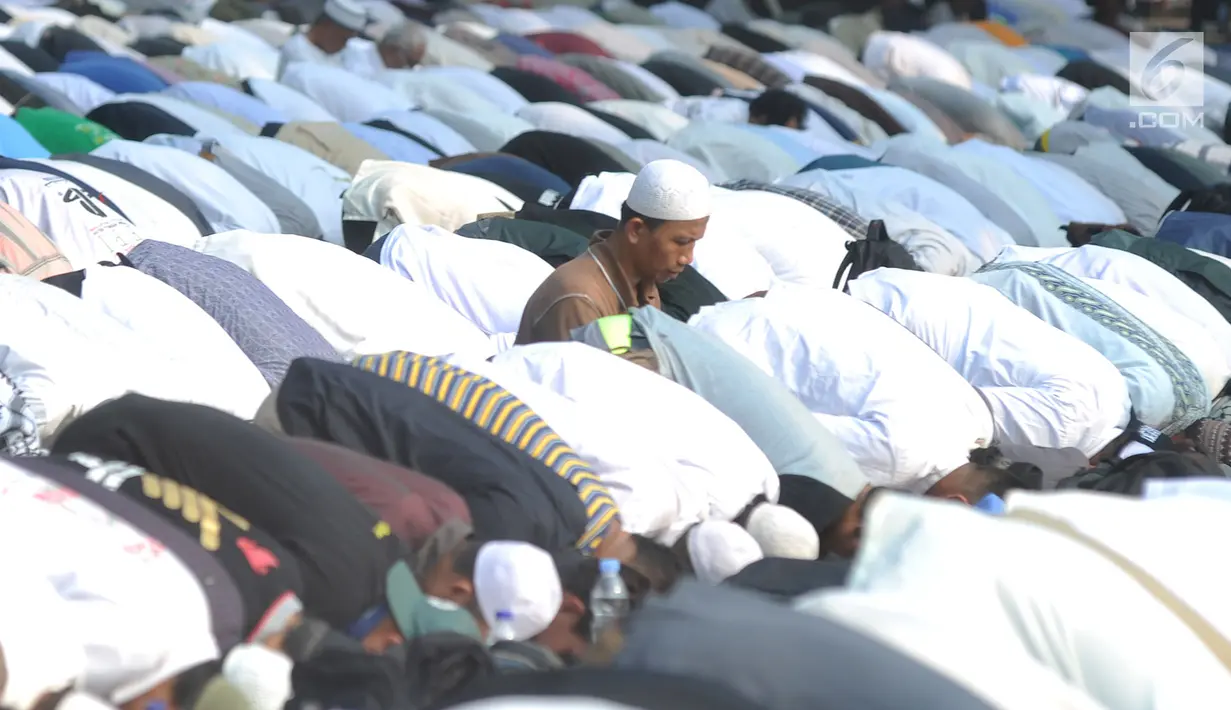 Massa pendukung pasangan capres-cawapres Prabowo Subianto dan Sandiaga Uno melakukan salat asar di Jalan Medan Merdeka Barat, Jakarta, Kamis (27/6/2019). Aksi tersebut dilakukan jelang putusan perselisihan hasil pemilihan umum (PHPU) Pilpres 2019 di Gedung MK. (merdeka.com/Arie Basuki)