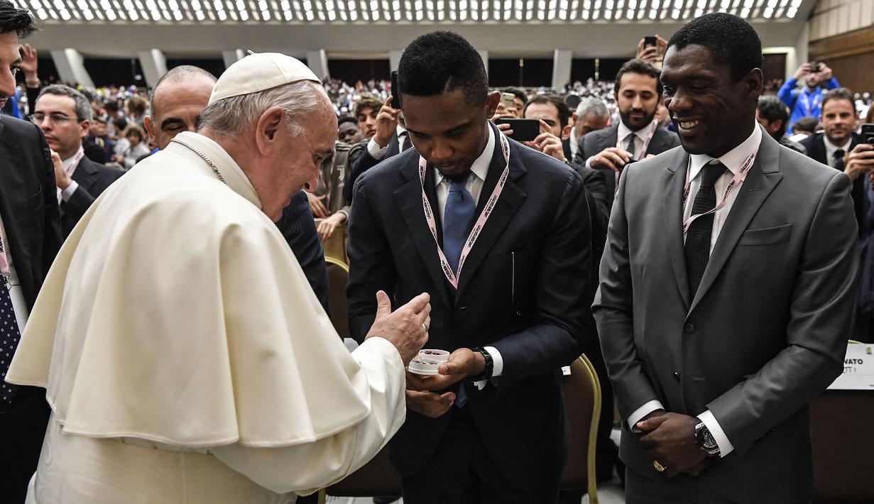 Paus Fransiskus menyalami mantan pesepak bola Kamerun, Samuel Eto'o (tengah) dan mantan pesepak bola Belanda, Clarence Seedorf  (kanan) dalam acara bertajuk "sepakbola yang kita cintai" ("Il calcio che amiamo"), yang diselenggarakan oleh surat kabar olahraga Italia "La gazzetta dello sport" dan federasi sepak bola Italia FIGC, di aula Paul-VI, Vatikan, 24 Mei 2019. (AFP/Vatican Media)