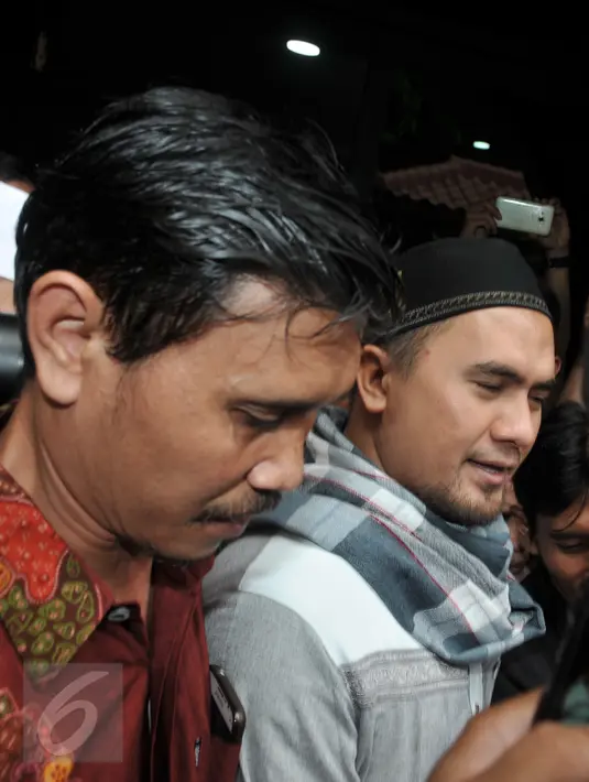 Tersangka kasus pencabulan yang juga pedangdut, Saipul Jamil saat akan keluar untuk melakukan shalat Jumat di Polsek Kelapa Gading, Jakarta, Jumat (19/2). Dengan menggunakan baju koko, Saipul keluar dengan kawalan ketat petugas. (Liputan6.com/Johan Tallo)