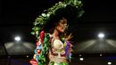 Model mengenakan busana rancangan desainer Kolombia, Alejandro Ramos selama BioFashion Show di Cali  pada 17 November 2018. Busana-busana yang ditampilkan di ajang ini seluruhnya terbuat dari tanaman hidup, bunga dan unsur organik lain. (Luis ROBAYO/AFP)