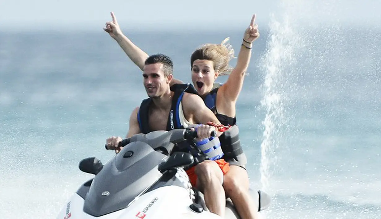 Robin van Persie bersama seorang teman mengendarai motor boat ketika liburan di Barbados (17/07/2014) (dailymail.co.uk)