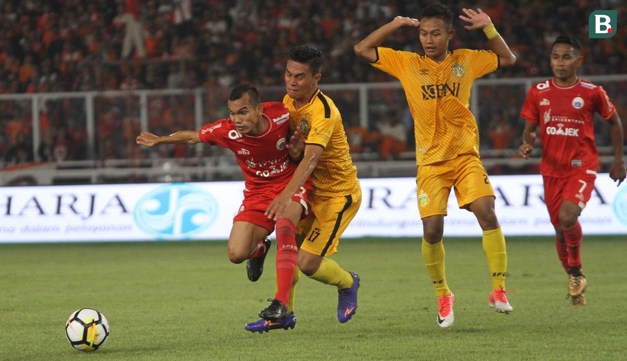 Gelandang Persija Jakarta, Riko Simanjuntak, berusaha melewati gelandang Bhayangkara FC, Alsan Sanda, pada laga Liga 1 di SUGBK, Jakarta, Jumat (23/3/2018). Kedua klub bermain imbang 0-0. (Bola.com/Asprilla Dwi Adha)