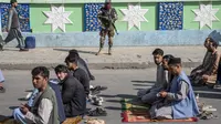 Seorang pejuang Taliban berjaga-jaga saat warga Afghanistan menghadiri sholat Idul Fitri, menandai akhir bulan puasa Ramadhan, di Kabul, Afghanistan, Jumat, 21 April 2023. (AP Photo/Ebrahim Noroozi)