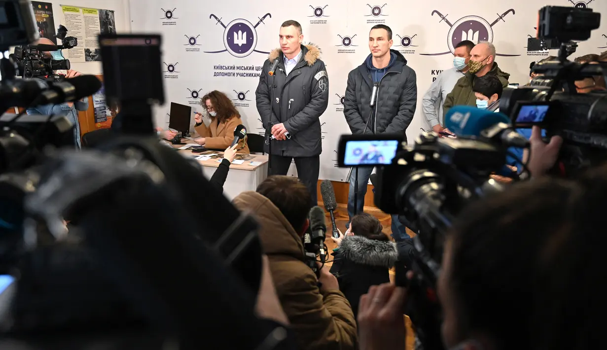Wali Kota Kiev, Vitali Klitschko (kiri) dan saudaranya yang mantan petinju Ukraina Wladimir Klitschko berbicara kepada pers saat pembukaan pusat rekrutmen Pasukan Pertahanan Wilayah di Kiev, 2 Februari 2022. Wladimir Klitschko mendaftar menjadi tentara cadangan Ukraina. (Genya SAVILOV/AFP)