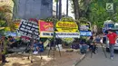 Sejumlah awak media berada di dekat karangan bunga di komplek Mako Brimob Kelapa Dua, Depok, Jawa Barat, Jumat (11/5). Karangan bunga ucapan bela sungkawa bertuliskan 'kami tidak takut, kami bersama Polri'. (Liputan6.com/Herman Zakharia)