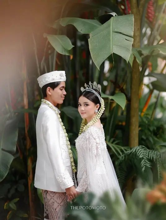 Dalam gambar yang diunggah, Kayess dan Celiboy terlihat mengenakan busana adat Jawa sebagai pengantin. Mereka dengan bangga menunjukkan foto buku pernikahan mereka. (Liputan6.com/IG/@ewkharis)