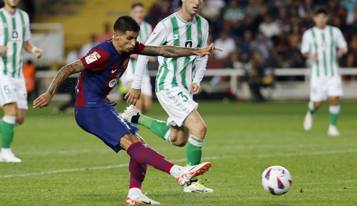 Pemain Barcelona, Joao Cancelo, mencetak gol ke gawang Real Betis pada laga Liga Spanyol di Estadi Olimpic Lluis Companys, Minggu (17/9/2023). Barca menang dengan skor 5-0. (AP Photo/Joan Monfort)