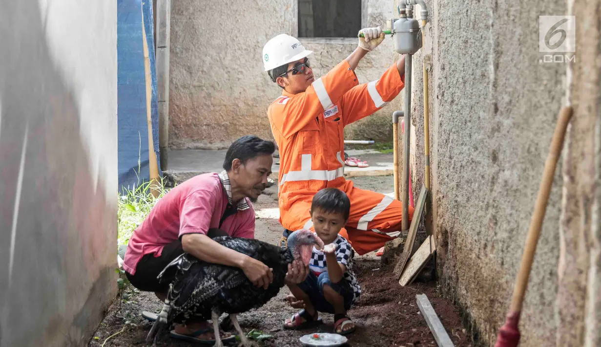 Petugas PT Perusahaan Gas Negara (PGN) memeriksa meteran jaringan gas bumi di perumahan warga di kawasan Cibinong, Bogor, Jawa Barat, Jumat (14/12). Pemerintah melalui PGN memberi tambahan 5.120 jargas pada tahun 2018. (Liputan6.com/Immanuel Antonius)
