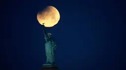 Pemandangan ketika Patung Liberty dihiasi oleh supermoon di Brooklyn, New York, Amerika Serikat, Rabu (31/1). (AP Photo/Julio Cortez)