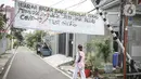 Pejalan kaki melintas di bawah spanduk peringatan untuk pemudik di kawasan Kartini, Sawah Besar, Jakarta, Senin (17/5/2021). Spanduk tersebut untuk memperingati warga yang kembali dari mudik lebaran agar membawa surat bebas COVID-19. (Liputan6.com/Faizal Fanani)