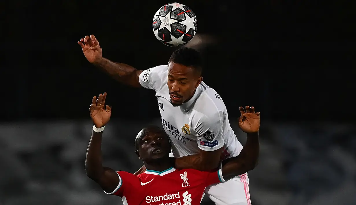 Bek Real Madrid, Eder Militao (atas) berduel udara dengan striker Liverpool, Sadio Mane dalam laga leg pertama babak perempatfinal Liga Champions 2020/2021 di Alfredo di Stefano Stadium, Selasa (6/4/2021). Real Madrid menang 3-1 atas Liverpool. (AFP/Gabriel Bouys)