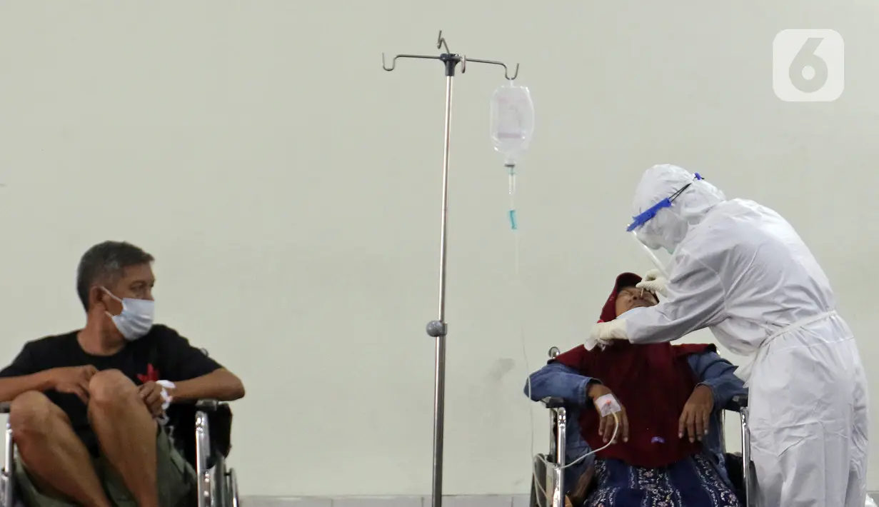 Petugas medis (kanan) yang mengenakan hazmat melakukan tes usap PCR di selasar IGD RSUD Cengkareng, Jakarta, Rabu (23/6/2021). Meningkatnya kasus COVID-19 di Ibu Kota Jakarta dalam beberapa hari terakhir mengakibatkan rumah sakit kewalahan. (Liputan6.com/Herman Zakharia)
