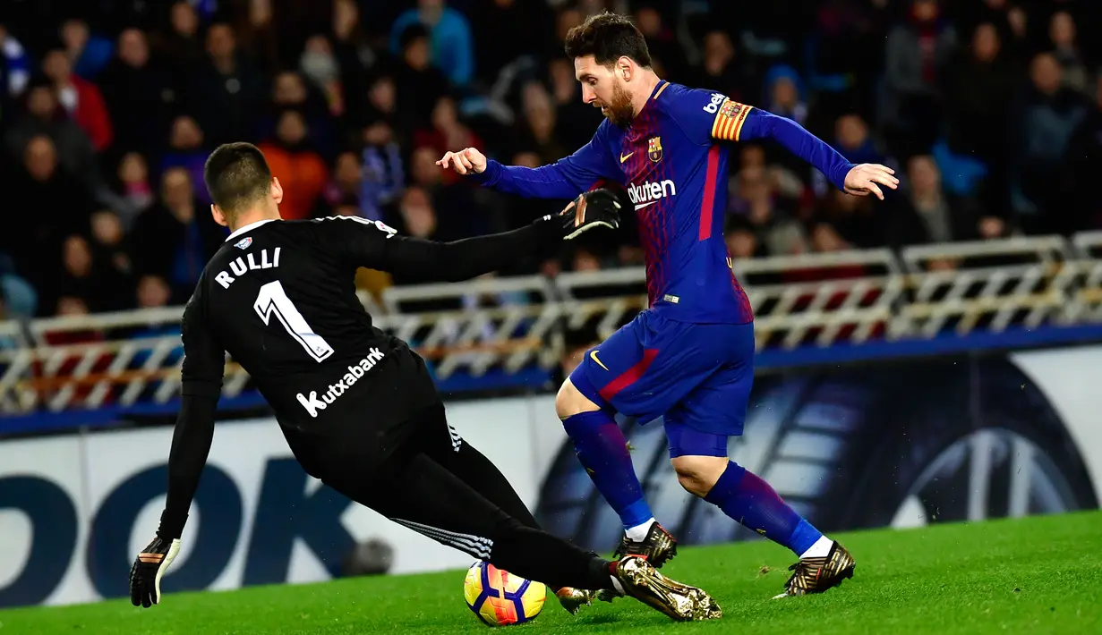 Pemain Barcelona, Lionel Messi berebut bola dengan kiper Real Sociedad, Geronimo Rulli pada laga pekan ke-19 La Liga di Stadion Anoeta, Minggu (14/1). Messi menyumbang gol yang membawa Barcelona tundukkan Real Sociedad 4-2. (AP/Alvaro Barrientos)