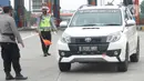 Polisi memberhentikan kendaraan di Gerbang Tol Palimanan, Jakarta, Jumat, (7/5/2021). Gerbang Tol Palimanan terpantau sepi pemudik dan didominasi oleh kendaraan angkutan barang pada hari kedua penyekatan. (merdeka.com/Imam Buhori)