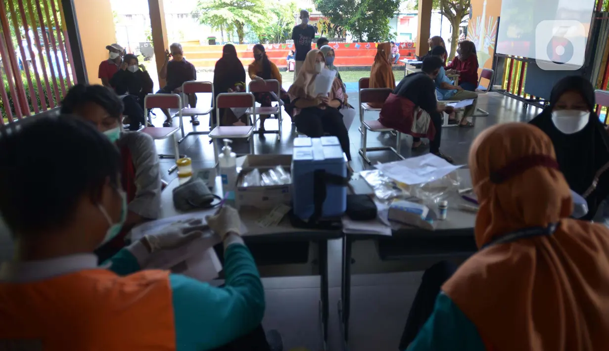 Warga menunggu untuk mendapatkan vaksin dosis ketiga (Booster) di RPTRA Kopi Gandaria, Pasar Rebo, Jakarta, Jumat (15/7/2022). Pemerintah Indonesia mewajibkan vaksinasi booster sebagai persyaratan untuk memasuki fasilitas publik/fasilitas umum antara lain perkantoran, tempat wisata, pusat perbelanjaan, dan area publik. (merdeka.com/Imam Buhori)