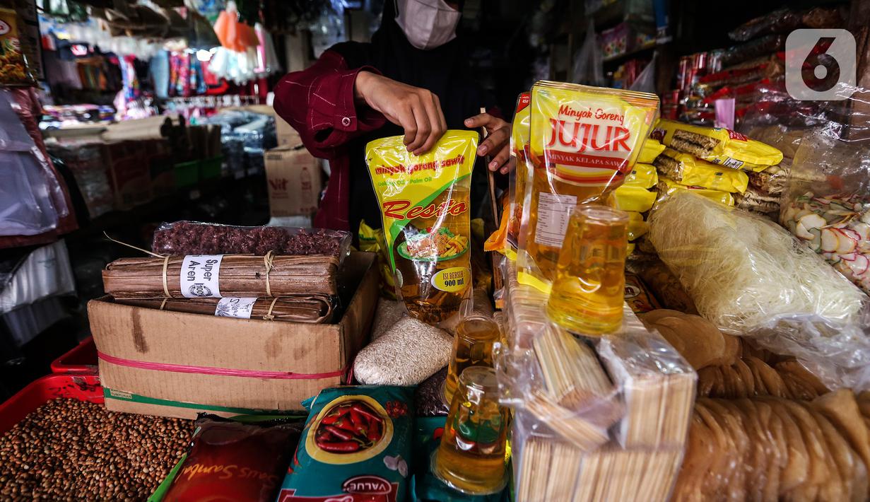 Penjual memperlihatkan minyak goreng kemasan di kiosnya Pasar Kebayoran Lama, Jakarta, Rabu (19/1/2022). Pemerintah resmi mengimplementasikan kebijakan minyak goreng satu harga Rp14.000 per liter untuk semua jenis kemasan mulai hari ini. (Liputan6.com/Johan Tallo)