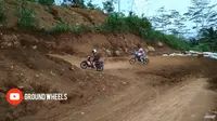 Pengendara motor bebek Honda Supra X masuk lintasan treck motor cross ketika para pembalap sedang melakukan latihan selepas race Grass Track, di sirkuit kedungumpul, Kandangan, Temanggung, Jawa Tengah, Sabtu (8/12/2018). (Youtube Ground Wheels)