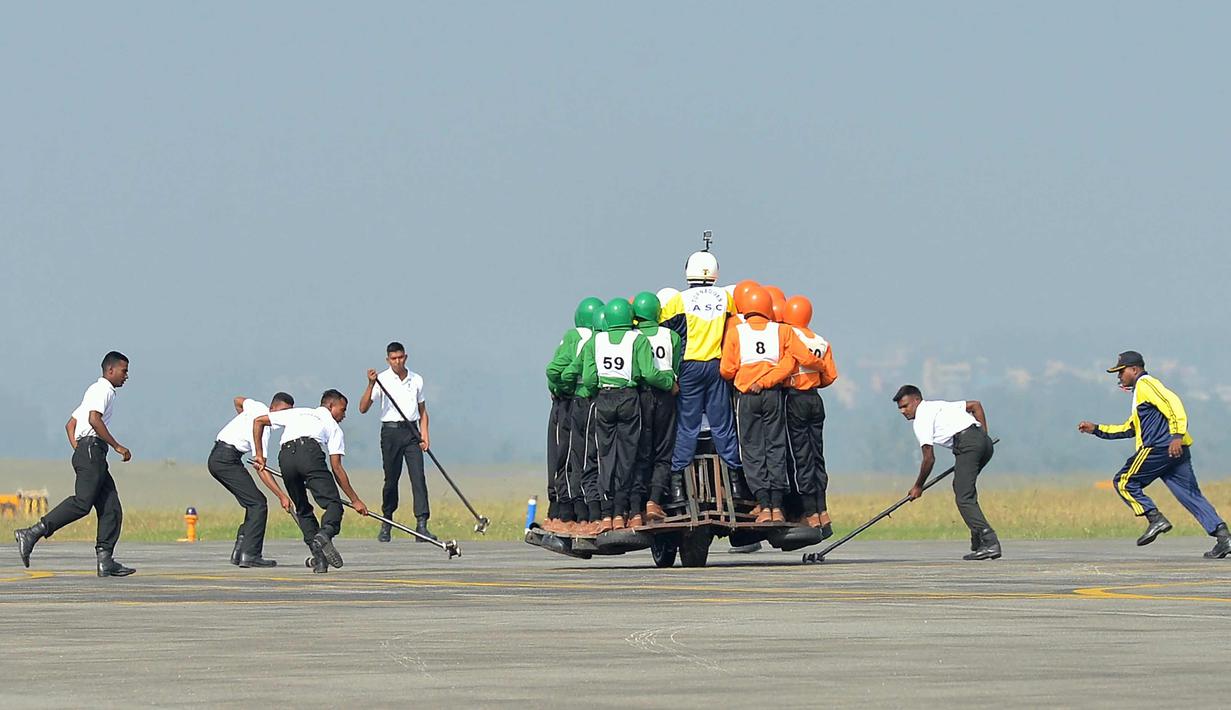 Tim Tornado dari Army Service Corps (ASC) saat memecahkan rekor dunia membawa 58 orang dengan satu motor 500 cc di Bangalore (19/11). Tim Tornado menciptakan rekor dunia baru setelah 58 orang naik satu motor 500 cc. (AFP Photo/Manjunath Kiran)