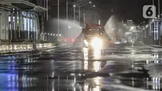 Petugas dari Dinas Penanggulan Kebakaran dan Penyelamatan DKI Jakarta menyemprotkan cairan disinfektan di sekitar Jalan Jenderal Sudirman-MH Thamrin, Jakarta, Kamis (31/12/2020). Jalan Jenderal Sudirman-MH Thamrin ditutup pada malam pergantian tahun 2020 menuju 2021. (Liputan6.com/Johan Tallo)