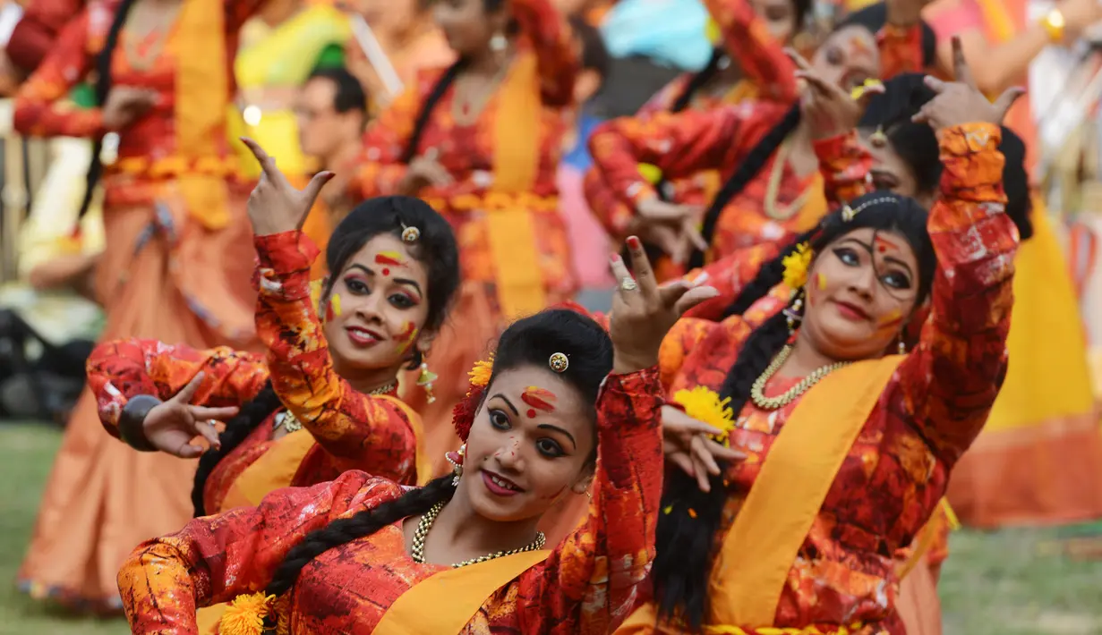 Sejumlah siswi menari selama perayaan Holi di Kolkata, India (7/3). Puncak perayaan Holi disebut Dhulheti, Dhulandi, atau Dhulendi. (AFP/Dibyangshu)