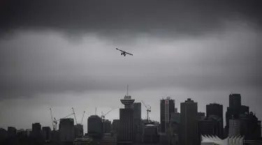 Sebuah pesawat amfibi lepas landas dari pelabuhan di bawah awan rendah di atas cakrawala pusat kota, di Vancouver, British Columbia, Kamis, (6/8/2020). (Darryl Dyck / The Canadian Press via AP)