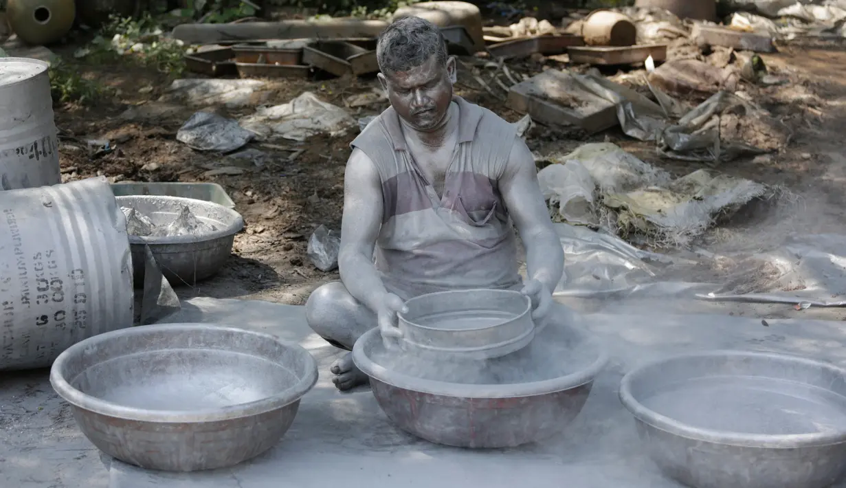 Seorang pekerja India mencampur bubuk mesiu untuk membuat petasan di sebuah pabrik di pinggiran Ahmadabad, Selasa (15/10/2019).  Menjelang Festival Diwali atau Festival Cahaya, produsen petasan di india dibanjiri pesanan. (AP Photo/Ajit Solanki)