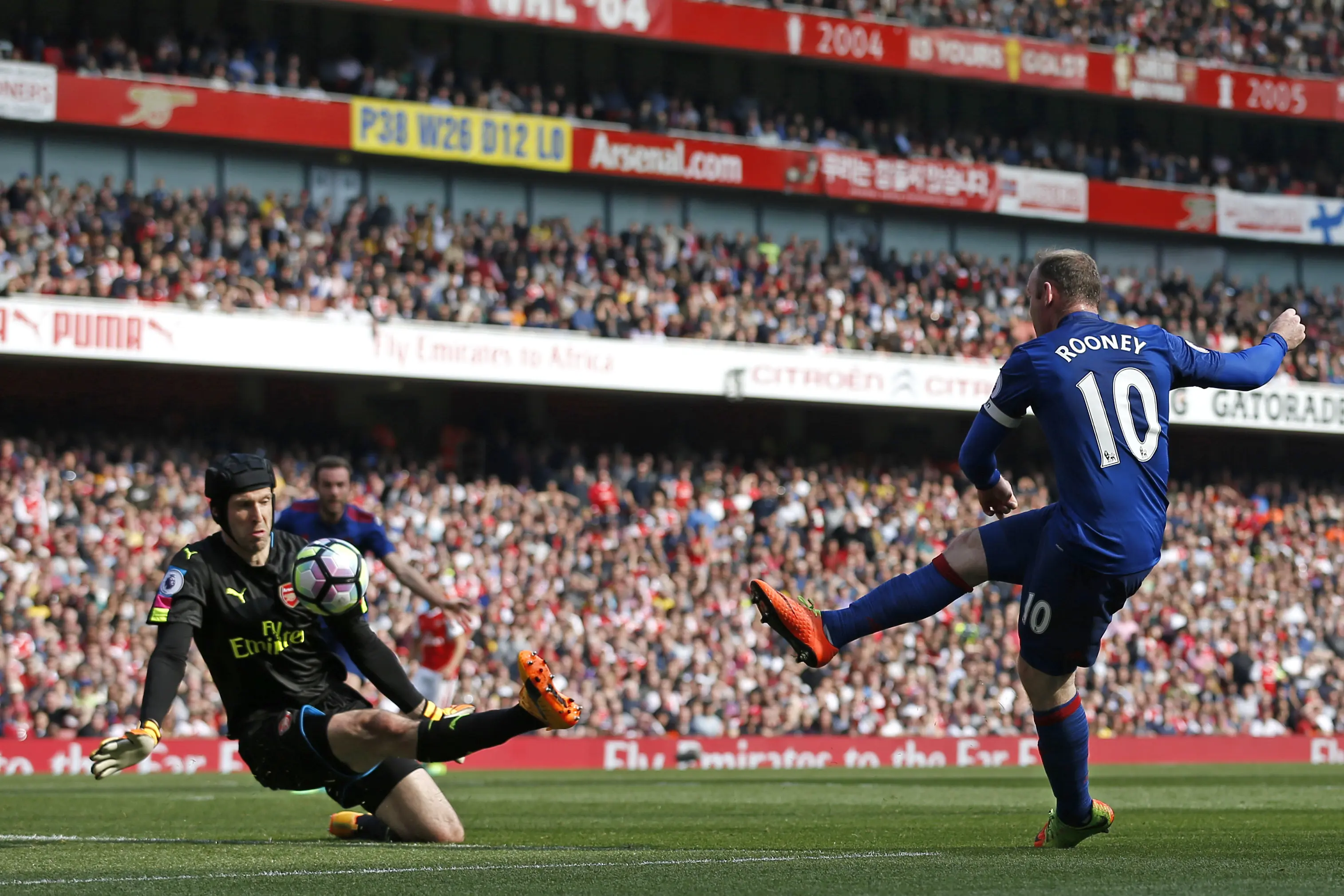 Momen saat penyerang Manchester United (MU), Wayne Rooney saat gagal menjebol gawang Arsenal kawalan Petr Cech. (Ian KINGTON / IKIMAGES / AFP)