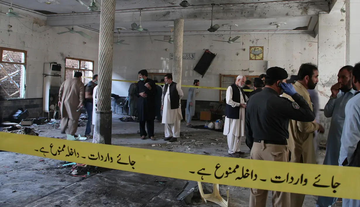Petugas penyelamat dan aparat kepolisian memeriksa lokasi ledakan bom di sebuah madrasah di kota Peshawar, Pakistan, Selasa (27/10/2020). Lebih dari 60 orang sedang ada di ruang salah satu kelas saat itu, ketika ledakan mengguncang pada Selasa  pagi. (AP Photo/Muhammad Sajjad)