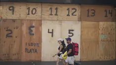 Orang-orang berjalan melewati etalase toko suvenir yang dipasangi papan persiapan kedatangan Badai Beryl, di Playa del Carmen, Meksiko, Kamis (4/7/2024). (AP Photo/Fernando Llano)