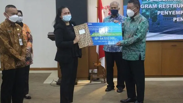 Dirjen Industri Kimia, Farmasi, dan Tekstil (IKFT) Kemenperin Muhammad Khayam menyerahkan Potongan Harga Pembelian Mesin atau Peralatan Industri Penyempurnaan Kain dan Industri Pencetakan Kain ke PT Dunia Setia Sandang Asli Tekstil. (Dok Kemenperin)