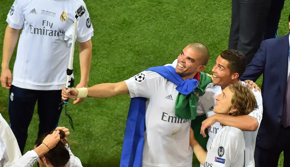 Pepe, Cristiano Ronaldo dan Luka Modric melakukan selfie usai menang melawan Atletico Madrid pada Final Liga Champions di San Siro Stadium, Milan, (29/5/2016) WIB. (AFP/Giuseppe Cacace)