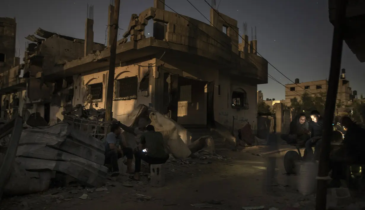 Warga Palestina bermalam di samping rumah mereka yang hancur baru-baru ini terkena serangan udara Israel di kota Beit Hanoun, Jalur Gaza utara, Rabu (26/5/2021). Warga Palestina mulai kembali ke rumah mereka yang hancur setelah gencatan senjata diberlakukan dalam perang Gaza. (AP Photo/Khalil Hamra)